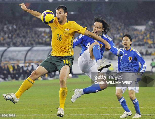 Australian player Mile Sterjovski defends the ball as Japanese defenders Markus Tulio Tanaka and Hideo Hashimoto attempt to take possesion of the...