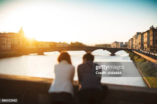 paar von touristen in florenz, in italien - roman bridge stock-fotos und bilder