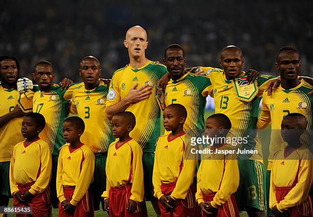 Matthew Booth of South Africa stands with his teammates listening to his countries national anthem prior to the FIFA Confederations Cup match between...