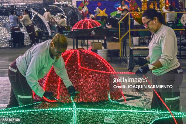 Women work in the preparation of Christmas lights arrangements to decorate the streets of Medellin, Colombia on November 16, 2017. According to EPM...