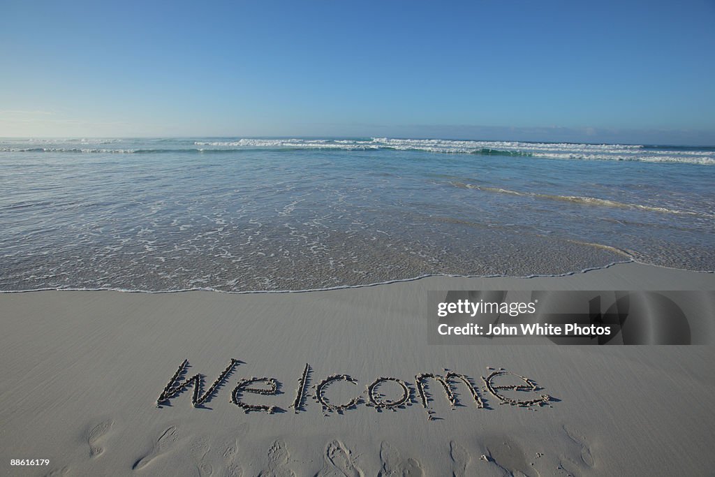 Welcome written on a clean beach