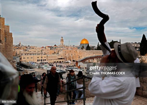 General view shows a Jewish man blowing a Shofar near the Western Wall and the Dome of the Rock in the Al-Aqsa mosque compound in the Old City of...