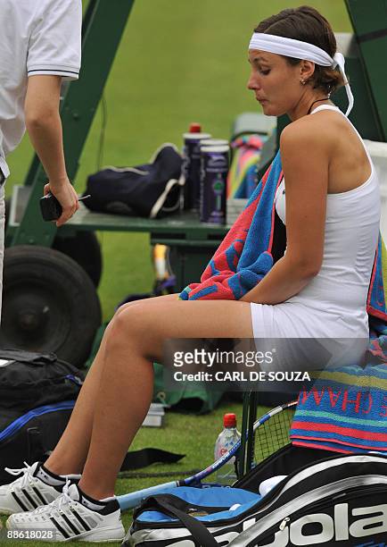 France's Severine Bremond Beltrame is assisted after injury during play against Belarus' Victoria Azarenka during their first round match of the 2009...