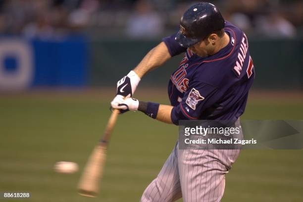 Joe Mauer of the Minnesota Twins makes contact with a pitch during the game against the Oakland Athletics at the Oakland Coliseum on June 9, 2009 in...