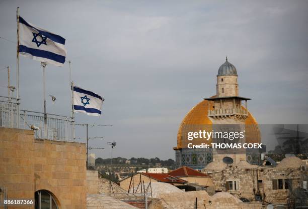 Israeli flags fly near the Dome of the Rock in the Al-Aqsa mosque compound on December 5, 2017. - The EU's diplomatic chief Federica Mogherini said...