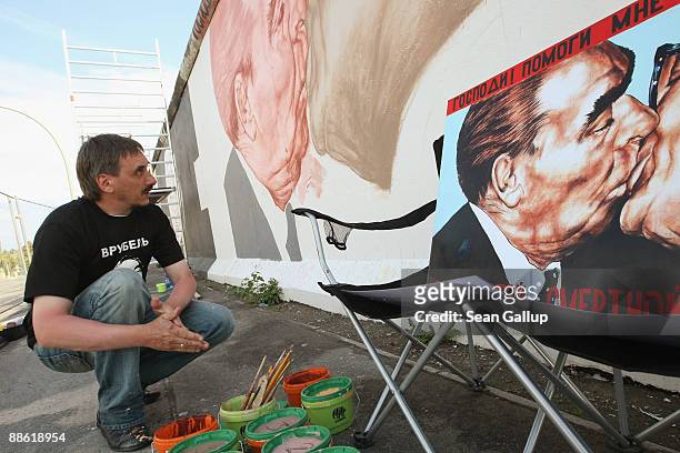 Russian artist Dmitry Vrubel preparees to continue painting his work in progress showing former Soviet leader Leonid Brezhnev kissing former...