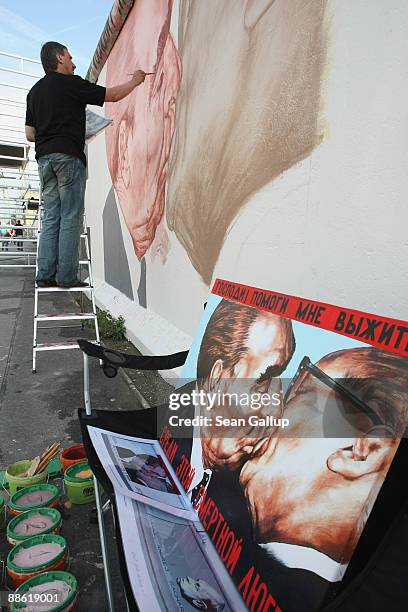 Russian artist Dmitry Vrubel repaints his historic mural showing former Soviet leader Leonid Brezhnev kissing former communist East German leader...