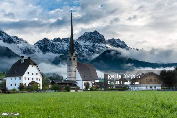 maria alm austria kirchturm mit schnee bedeckt berge - saalfelden stock-fotos und bilder