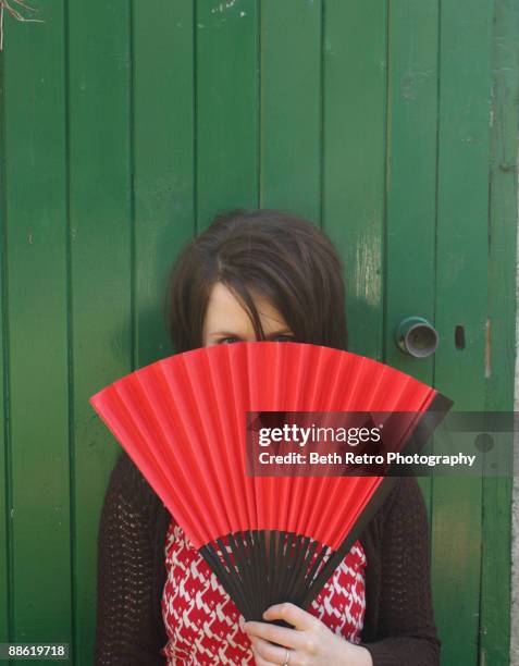 girl with a red fan - shy stockfoto's en -beelden