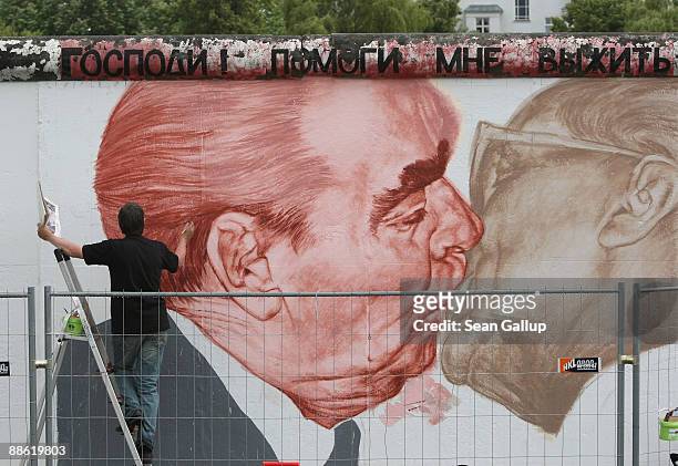 Russian artist Dmitry Vrubel repaints his historic mural showing former Soviet leader Leonid Brezhnev kissing former communist East German leader...