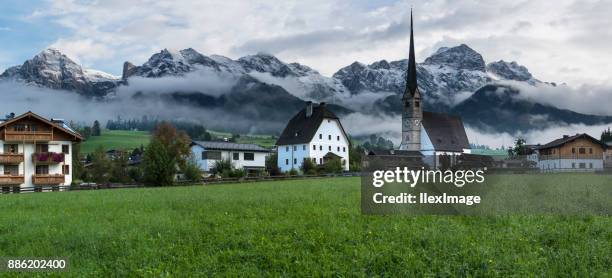 maria alm austria kirchturm mit schnee bedeckt berge panorama - saalfelden stock-fotos und bilder