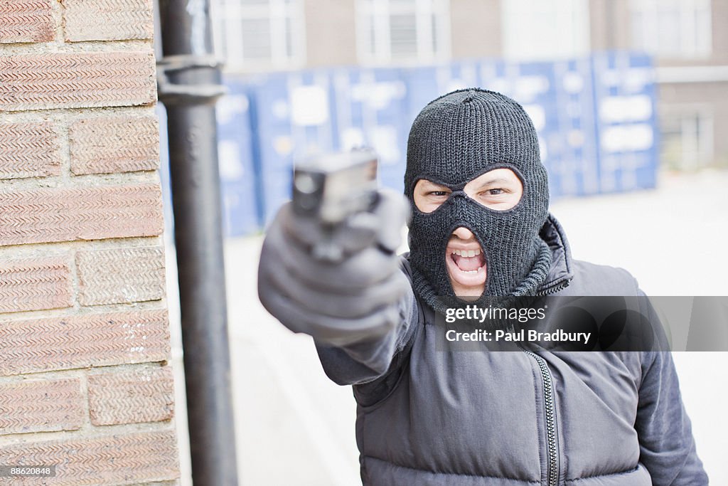 Man in skin mask holding gun