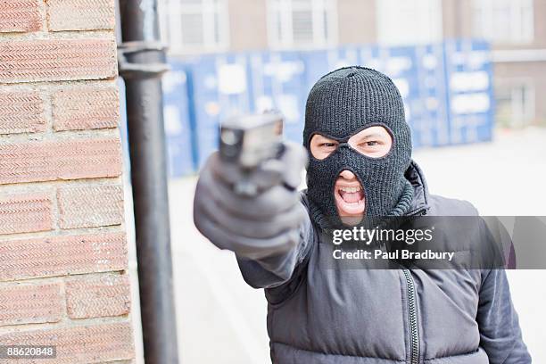 man in skin mask holding gun - mask confrontation stock pictures, royalty-free photos & images