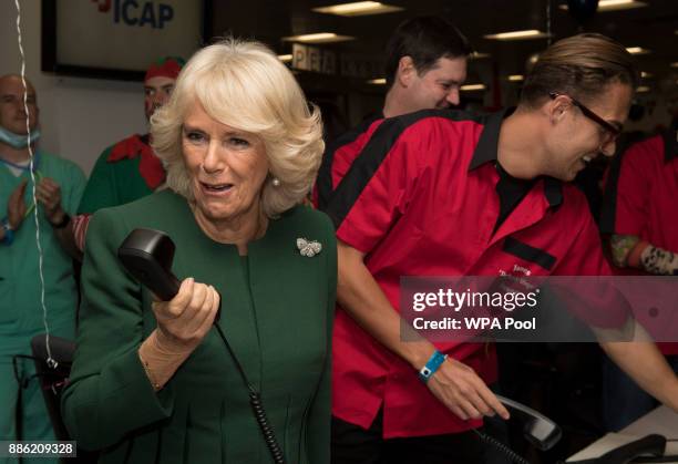 Camilla, Duchess of Cornwall, Patron, Medical Detection Dogs, on the phone during her visit to ICAP during the broker's annual ICAP charity day at...