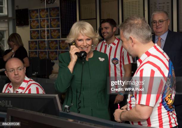 Camilla, Duchess of Cornwall, Patron, Medical Detection Dogs, on the phone during her visit to ICAP during the broker's annual ICAP charity day at...