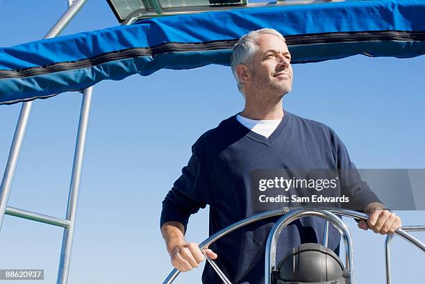 man steering boat - male sailing stockfoto's en -beelden