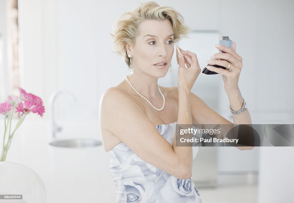 Glamorous woman putting on makeup