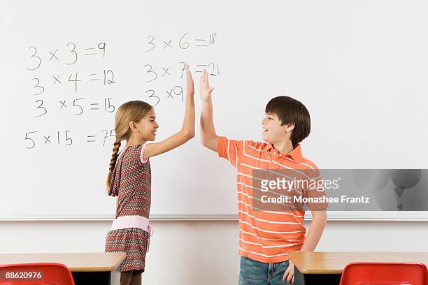 students high-fiving after completing math at whiteboard - mathematical symbol stock photos et images de collection