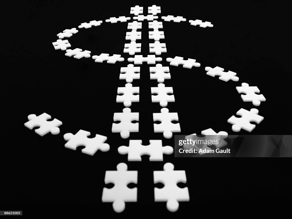 Puzzle pieces in shape of dollar sign