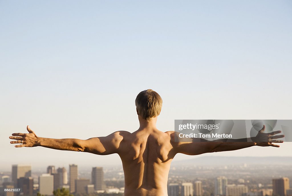 Bar poitrine Homme étirements sur le balcon avec vue sur la ville