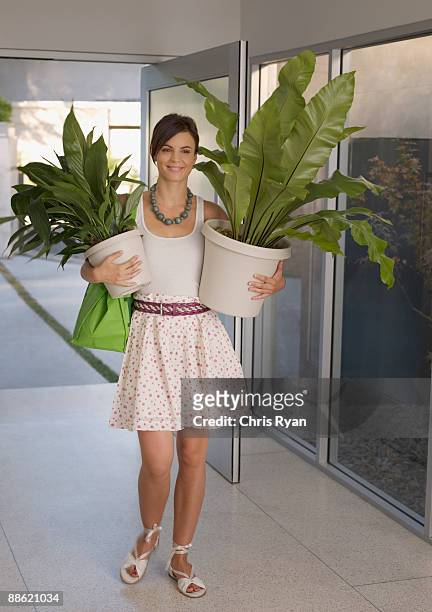 woman carrying plants - carrying pot plant stock pictures, royalty-free photos & images