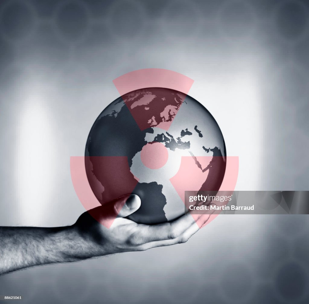 Man holding globe with overlay of nuclear symbol