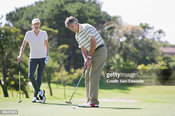 熟年カップル一緒のゴルフ - women golf ストックフォトと画像