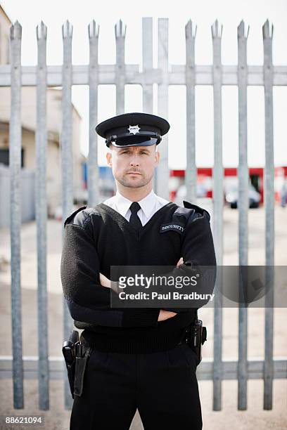 wachmann stehend vor gate - uk police stock-fotos und bilder
