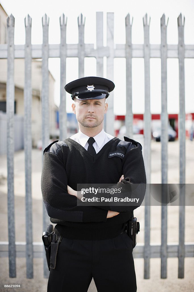 Guardia de seguridad de pie frente a la puerta