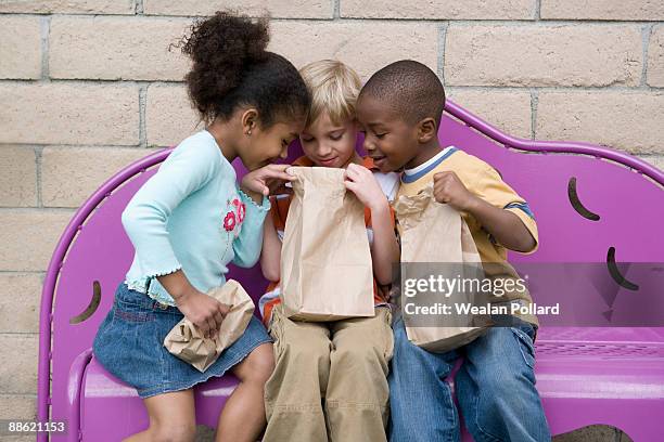 children looking in friends lunch bag at recess - pollard review stock pictures, royalty-free photos & images