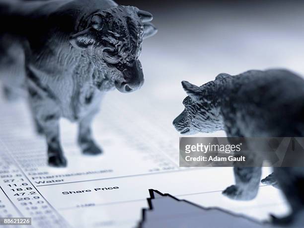 bull and bear figurines on list of share prices - bull bear stock-fotos und bilder