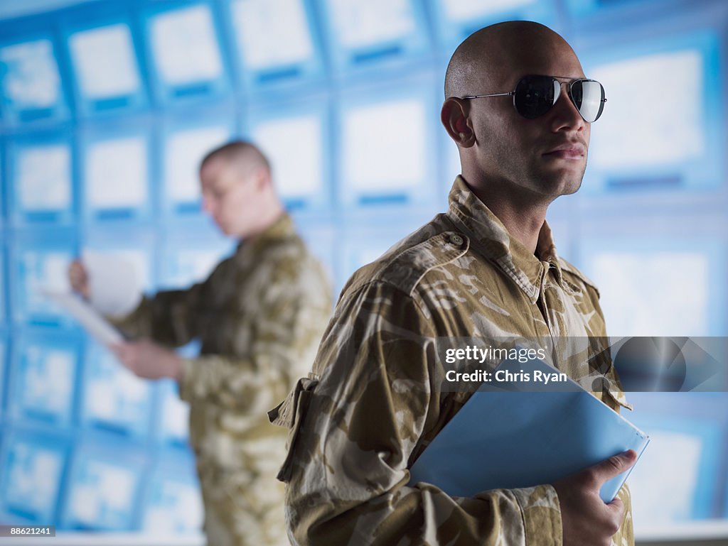 Man in camouflage holding folder
