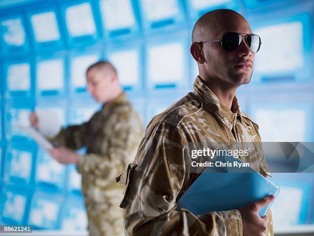 man in camouflage holding folder - central intelligence agency stock pictures, royalty-free photos & images