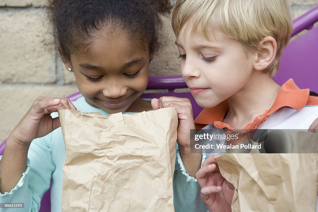 Boy looking in friends lunch bag at recess