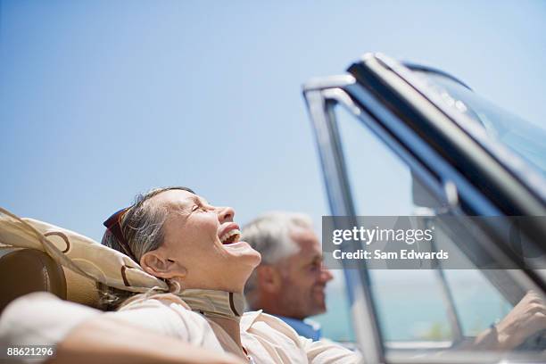 mature couple driving in convertible - driving happy stock pictures, royalty-free photos & images