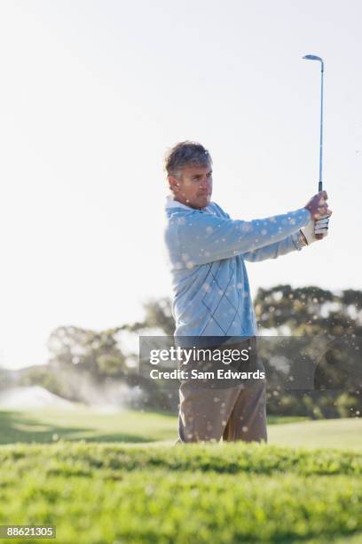 man playing golf in sand trap - golf bunker low angle stock pictures, royalty-free photos & images