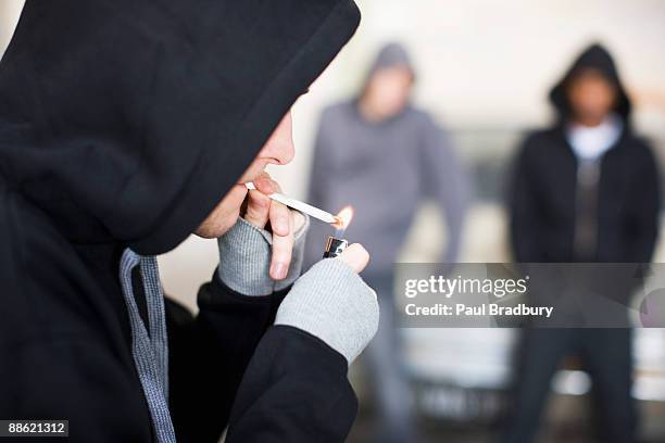 hombre iluminación cigarrillo de marihuana - marijuana joint fotografías e imágenes de stock