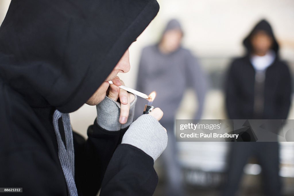 Man lighting marijuana cigarette