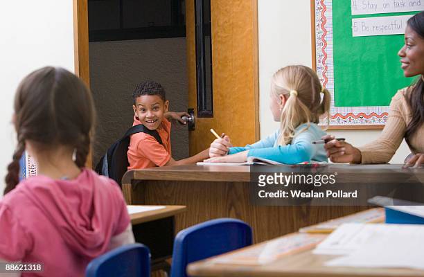 boy entering classroom late - arriving late class ストックフォトと画像