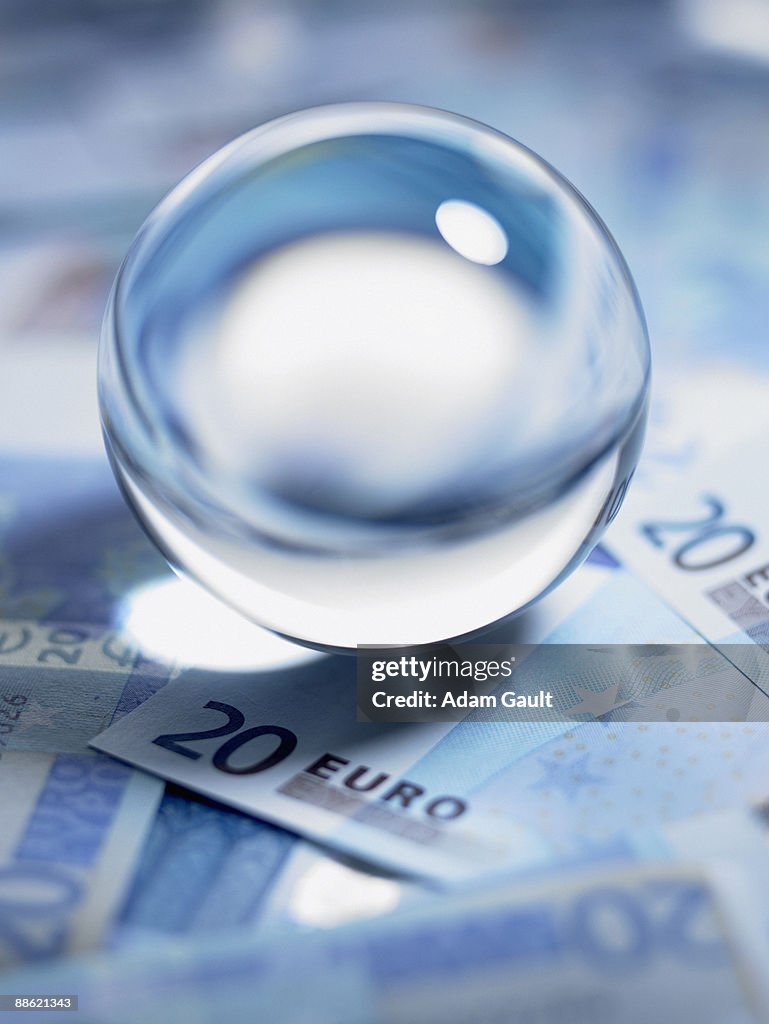 Close up of crystal ball on 20 euro notes