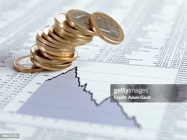 falling stack of euro coins on descending line graph - moeda de um euro imagens e fotografias de stock