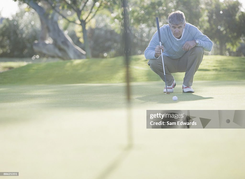 Man assessing play on putting green