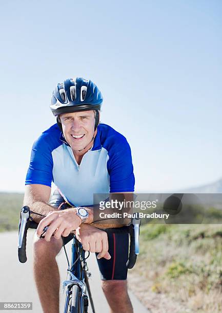 man in helmet sitting on bicycle - spandex stock pictures, royalty-free photos & images