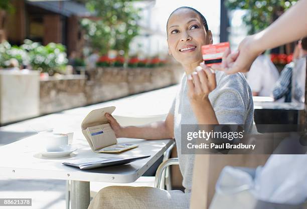 woman paying for coffee with credit card - payment card stock pictures, royalty-free photos & images