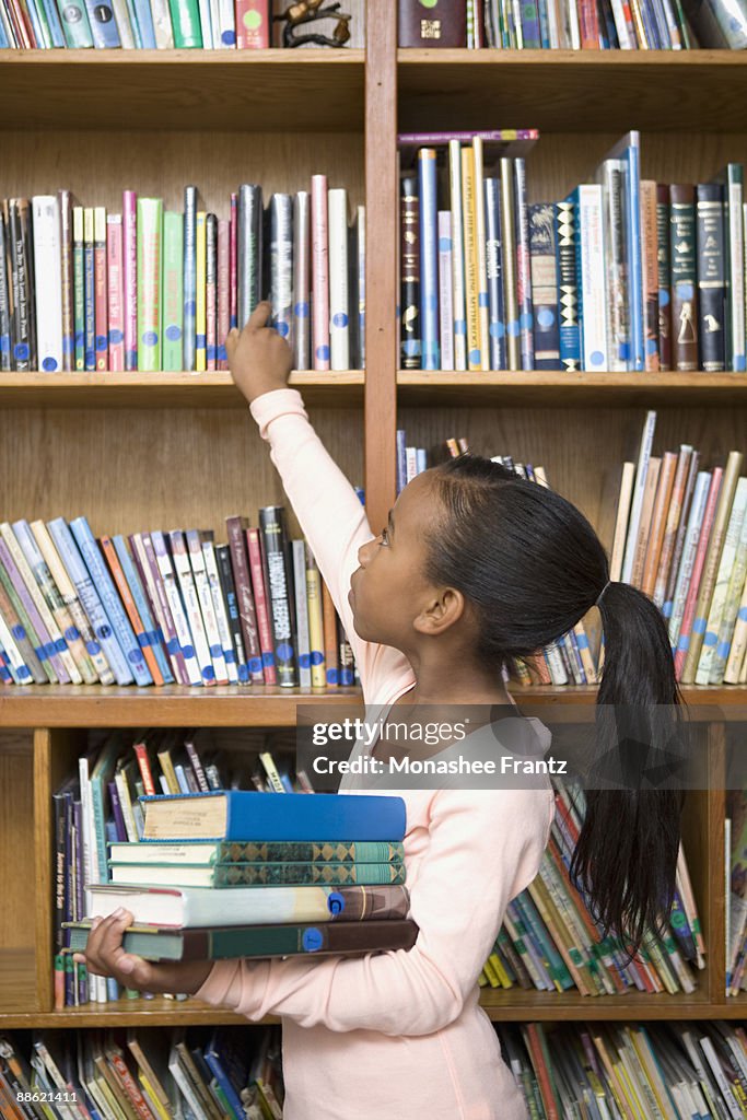 Girl taking books from school library