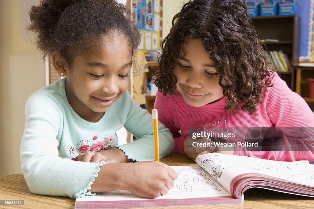 Girls working together on school work in classroom
