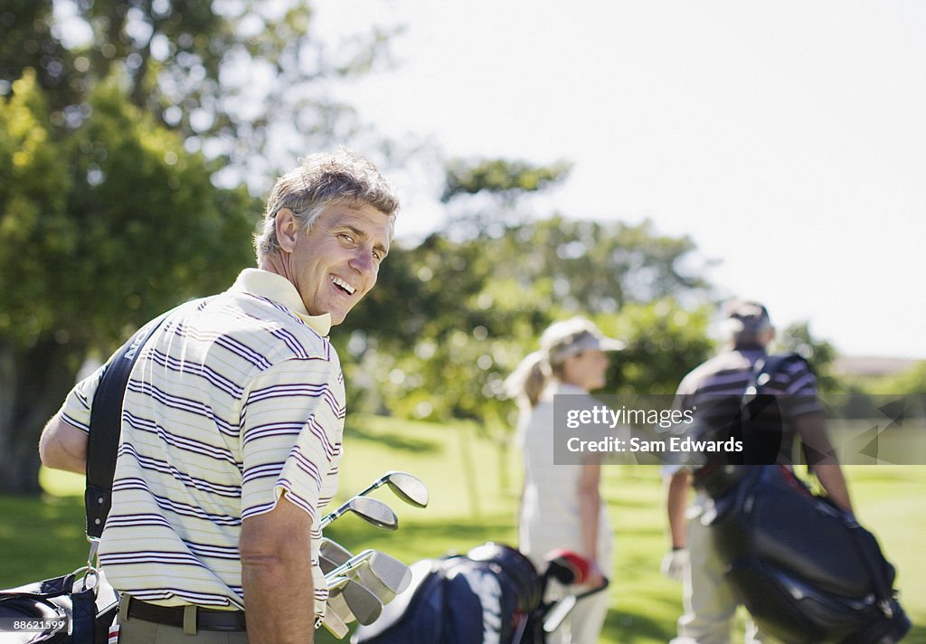 Friends carrying golf bags