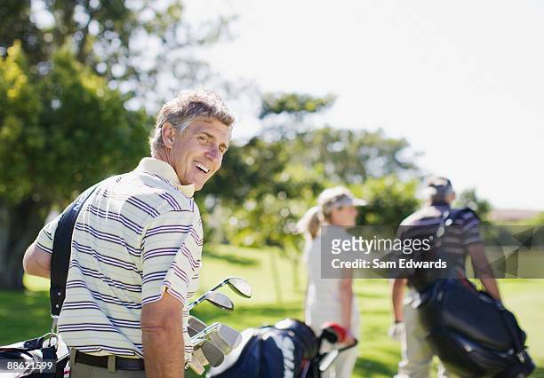 friends carrying golf bags - golfer stock pictures, royalty-free photos & images