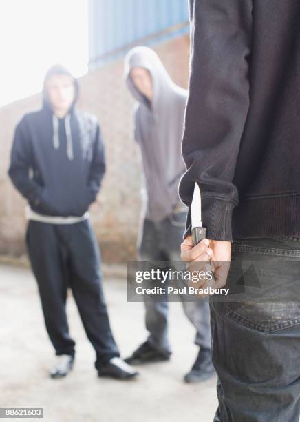 due uomini di essere affrontati da uomo con coltello - coltellino svizzero foto e immagini stock