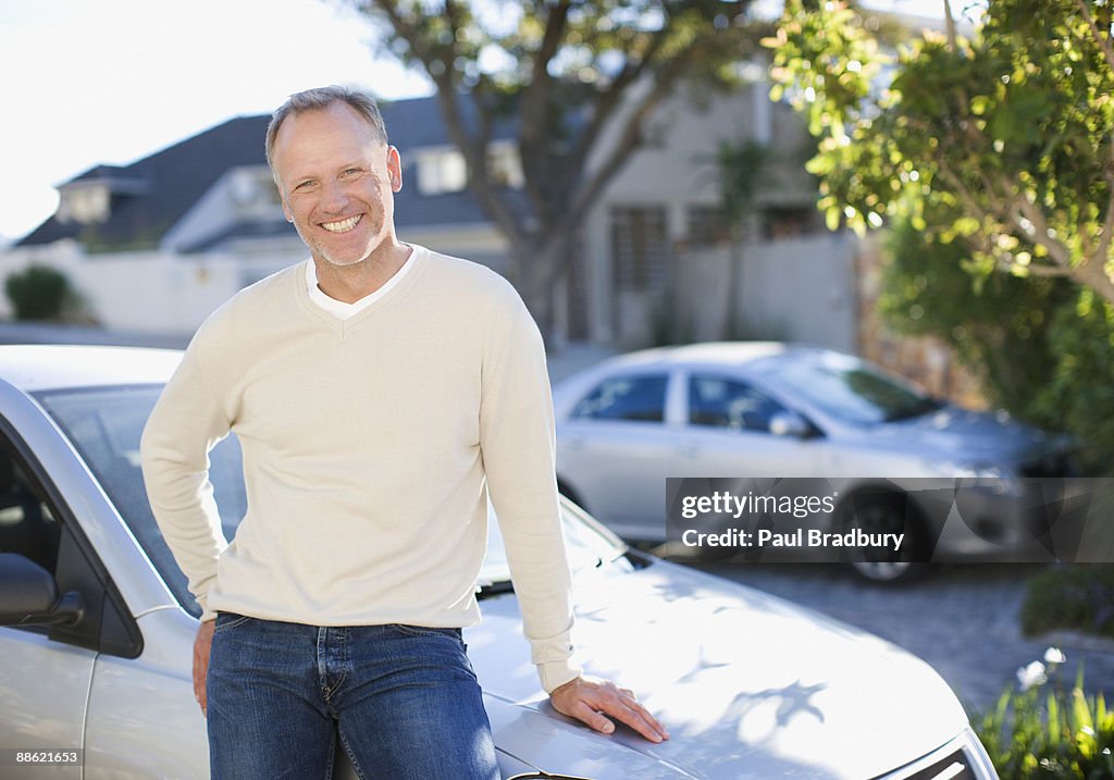 Man leaning on car hood